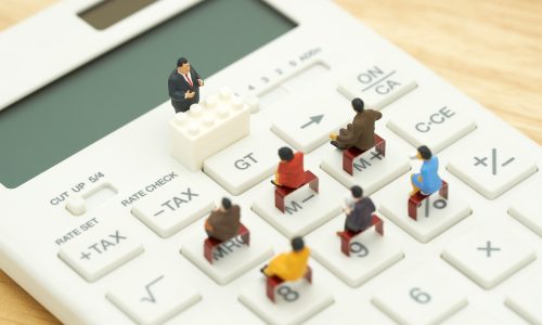 Miniature people Pay queue Annual income (TAX) for the year on calculator. using as background business concept and finance concept with copy space  for your text or  design.